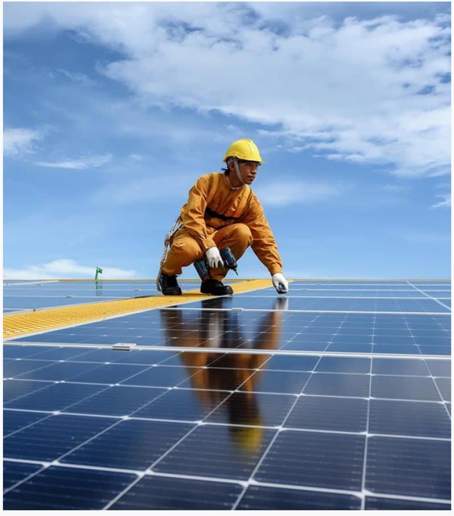 Technicien installant des panneaux solaires sur une centrale au sol